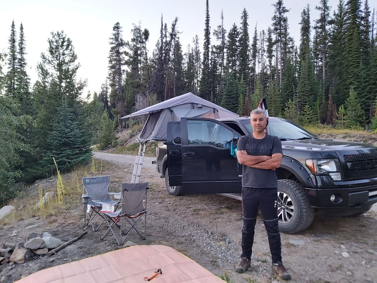 Bruce standing by his truck at a backcountry campsite