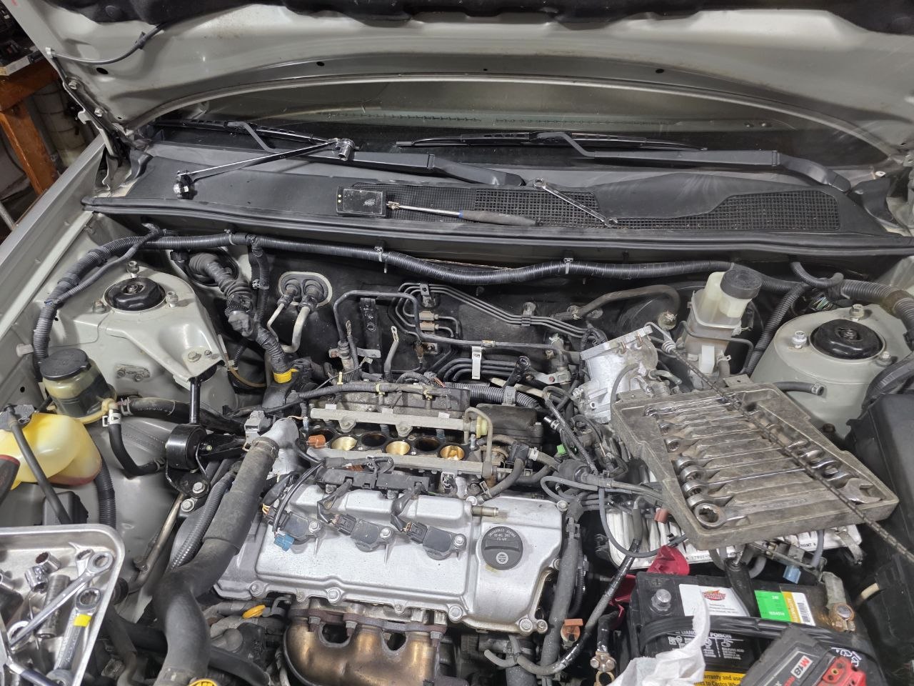Engine bay with ignition coils and spark plugs accessible during a tune-up